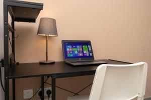 a laptop computer sitting on a desk with a lamp at Open Mind Property - Spacious 2BR Flat City Views in Portsmouth