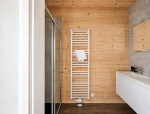 a bathroom with wooden walls and a glass shower at Nassfeld Chalet in Rattendorf
