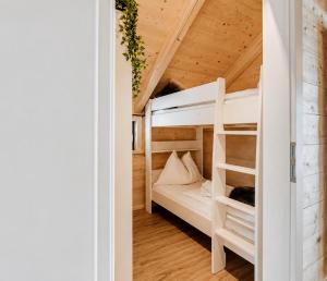 a bedroom with bunk beds in a wooden house at Nassfeld Chalet in Rattendorf +10 photos