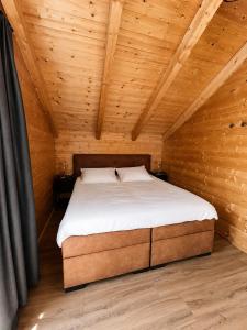 a bedroom with a bed in a wooden cabin at Nassfeld Chalet in Rattendorf