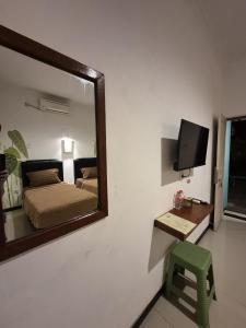 a mirror on the wall of a bedroom with a bed at Mulyanus Hotel by Calli Rooms in Wirolegi +18 photos