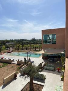 a building with a swimming pool next to a house at Villa Loanaelle in Marrakesh