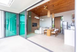 a kitchen and dining room with sliding glass doors at Siam Mila Villas in Srithanu