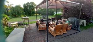 a deck with a table and chairs under an umbrella at Landgut Pinnow in Murchin