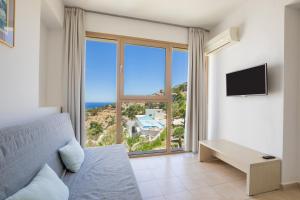 a bedroom with a bed and a large window at Renata's Villas in Karpathos