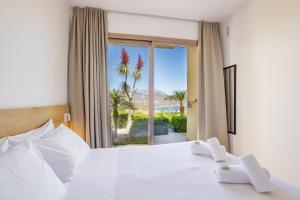 a bedroom with a bed with a view of the ocean at Renata's Villas in Karpathos +74 photos