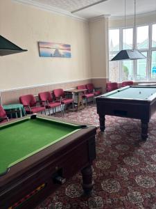 a room with a pool table and red chairs at Ashley Court Hotel in Torquay