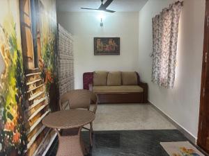 a living room with a couch and a table and chairs at Sreevara Farms in Hosūr