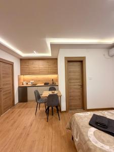 a room with a bed and a table and chairs at Taca 1 - Airport apartman in Surčin