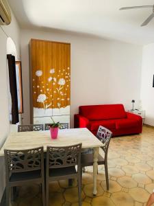 a living room with a table and a red couch at B&B Casa Chicchina in Ischitella
