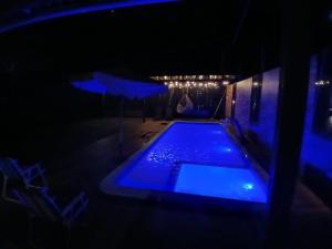 a swimming pool in a dark room with blue lighting at Casa Vale do Sal 2 in Salinópolis +28 photos