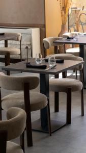 a group of tables and chairs with wine glasses on them at Hôtel Restaurant de la Place in Saint-Jean-dʼAngély