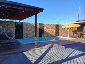 a patio with a pool and an umbrella at Casa Vale do Sal 2 in Salinópolis