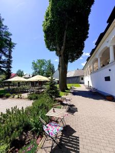 a group of tables and chairs next to a building at Kaštieľ Čičmany in Čičmany
