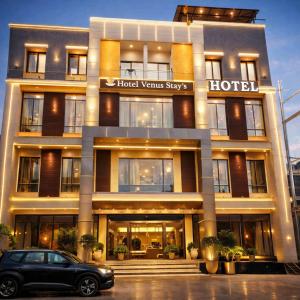 a building with a car parked in front of it at Hotel Venus Stays Near Prestige College Bhopal in Bhopal