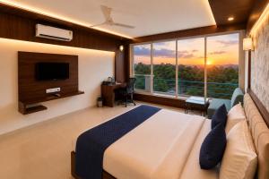 a bedroom with a bed and a large window at High Five Hotels Phase 2 in Assagao +19 photos