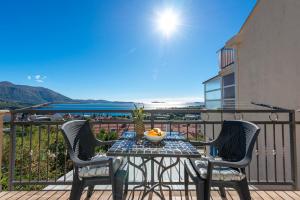 a table with chairs and a bowl of fruit on a balcony at Blue horizont in Mlini +6 photos