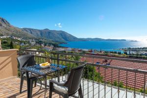 a balcony with a table and chairs and a view of the water at Blue horizont in Mlini