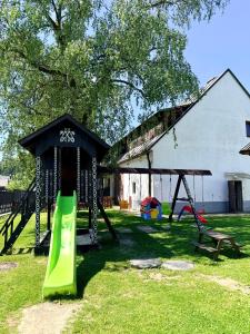 a playground with a slide and a swing set at Kaštieľ Čičmany in Čičmany