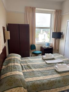 a hotel room with a bed and a window at Ashley Court Hotel in Torquay