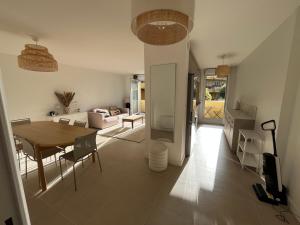 a living room with a table and a couch at Appartement avec piscine chauffée et Tennis proche Deauville in Touques