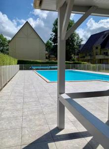 a patio with a swimming pool at Appartement avec piscine chauffée et Tennis proche Deauville in Touques