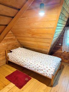 a bed in a room with a wooden ceiling at Leśny Zakątek Nowy Wiśnicz in Nowy Wiśnicz