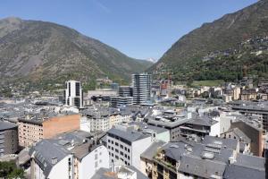 Luftaufnahme einer Stadt mit Gebäuden und Bergen in der Unterkunft Hotel Panorama in Andorra la Vella