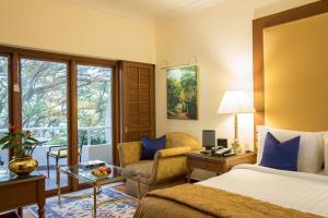 a hotel room with a bed and a chair at The Oberoi Bengaluru in Bangalore