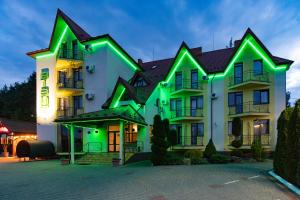a large white building with green lights on it at Hotel Restaurant Vizit in Truskavets