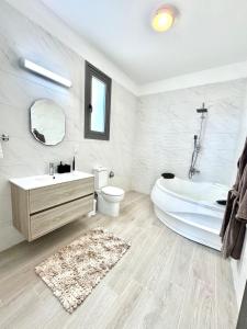 a bathroom with a tub and a toilet and a sink at Villa Tuludis in Drousha +51 photos