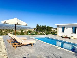 a villa with a swimming pool and an umbrella at Villa Tuludis in Drousha