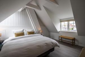 ein Schlafzimmer mit einem großen weißen Bett und einem Fenster in der Unterkunft Allinge Badehotel in Allinge + 25 Fotos
