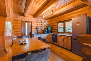 a kitchen with a table and a refrigerator at Holzhaus in Sadu