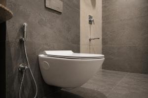 a bathroom with a white toilet and a shower at VANVASS - A Forest Resort By Rovers in Rāma