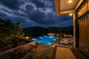 a view of a swimming pool at night at VANVASS - A Forest Resort By Rovers in Rāma +12 photos