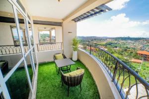 a balcony with a table and chairs and a view at Pecho Heights in Namulanda