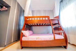 a bunk bed with a ladder in a room at Pecho Heights in Namulanda