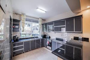 a kitchen with black and white appliances and a window at Pecho Heights in Namulanda