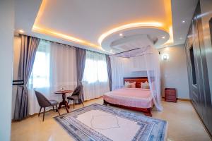 a bedroom with a canopy bed and a table at Pecho Heights in Namulanda