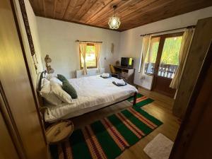 a bedroom with a bed and a desk and a window at Капсъзовата къща in Leshten