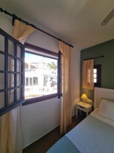 a bedroom with a bed and a large window at Posidonia -Son Bou Apartment in Son Bou