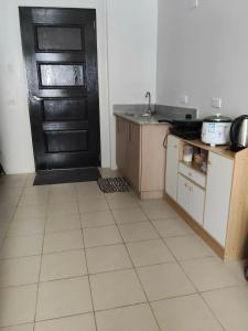 a kitchen with a black door and a tiled floor at Zefe's Hideout in Lapu Lapu City