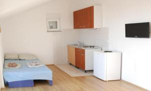 a kitchen with a bed and a sink in a room at Danica Roof in Tučepi