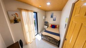 a small bedroom with a bed and a window at CLBC Residences - 2B in Ibaba