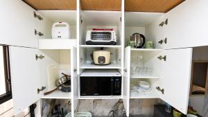 a kitchen with white cabinets and a microwave at CLBC Residences - 2B in Ibaba