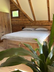 a bedroom with a bed and a potted plant at Green District - Riverside Luxury Lodge in Banja Luka