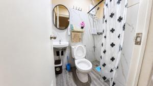 a bathroom with a toilet and a sink and a mirror at CLBC Residences - 2B in Ibaba +13 photos