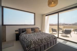 a bedroom with a bed and a large window at Villa Karuna by Aura Collection in Villaverde