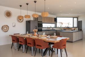 a kitchen and dining room with a wooden table and chairs at Villa Karuna by Aura Collection in Villaverde